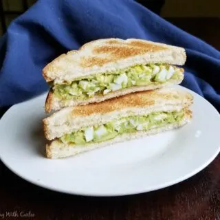 stack of 2 halves of an avocado egg salad sandwich.