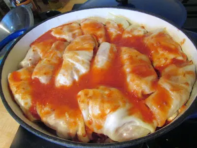 tomato sauce over stuffed cabbage rolls in casserole dish.