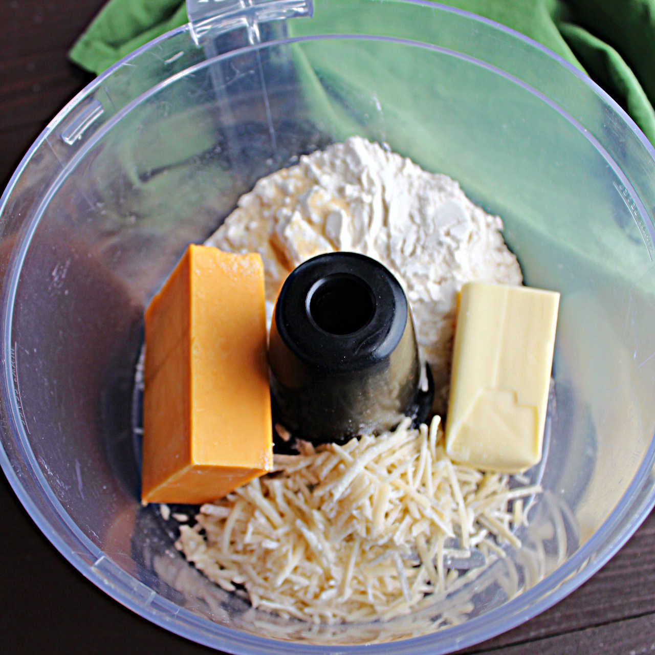 Cheese, butter and flour in food processor ready to be made into dough.