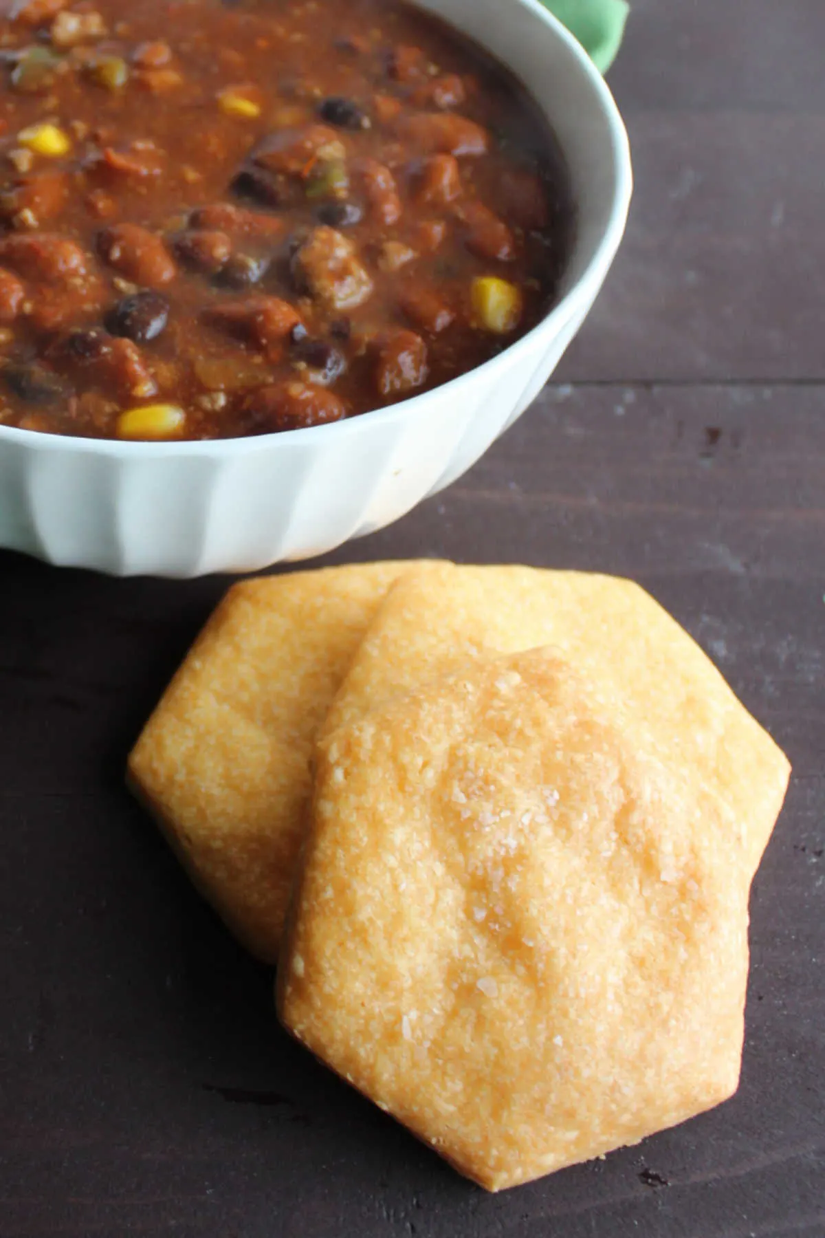 large homemade cheese crackers next to bowl of chili.