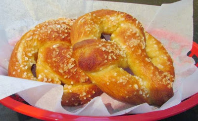 Two soft homemade pretzels in red plastic basket ready to eat.