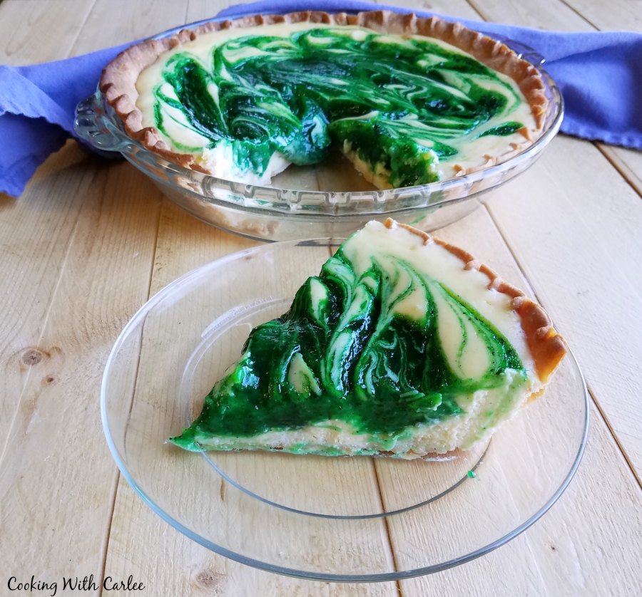 Slice of creamy pie with green swirls of kiwi in white filling.