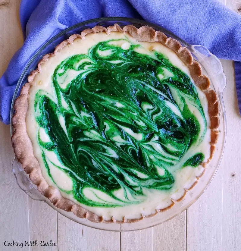 Whole kiwi and cream pie with green kiwi swirl in white cream base.