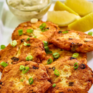 Close up of golden brown salmon patties with potato, ready to eat.
