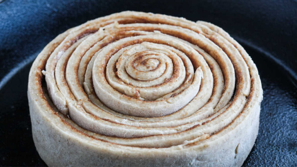 large cinnamon roll with concentric circles of dough and cinnamon.