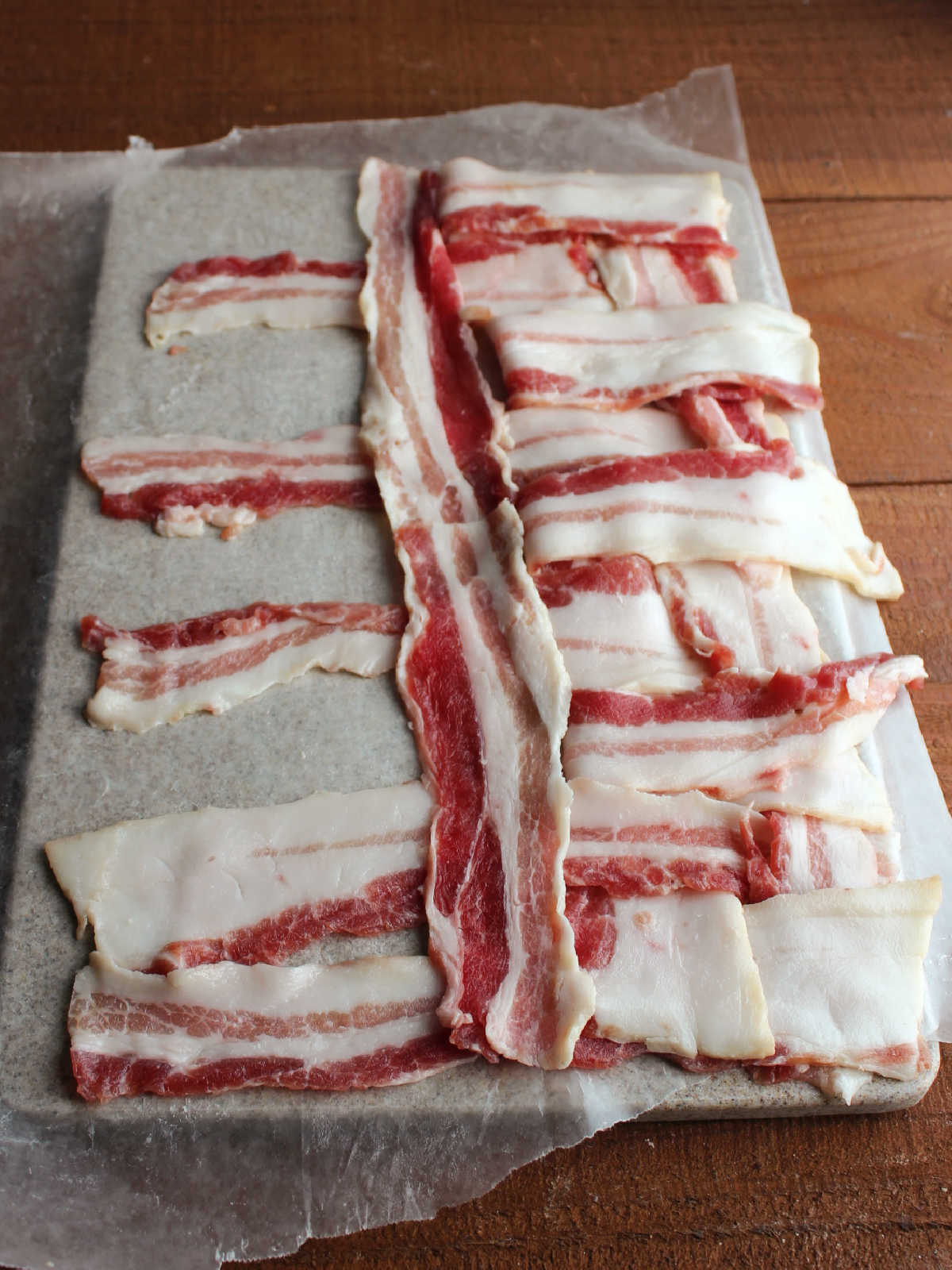 Weaving bacon slices with every other crosswise piece of bacon being folded back so a piece of bacon can be inserted going the other way.
