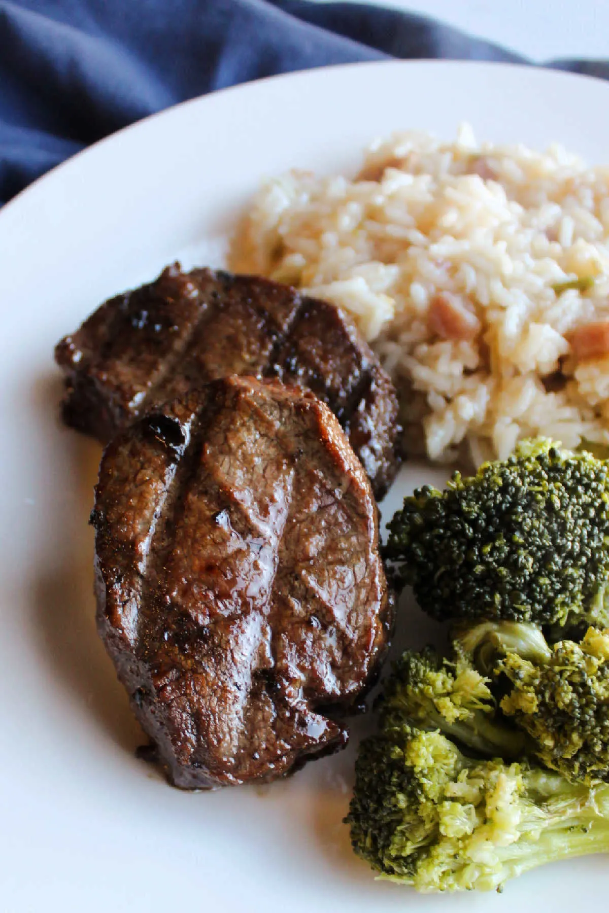 Grilled venison backstrap with bul kogi marinade on plate with broccoli and rice.
