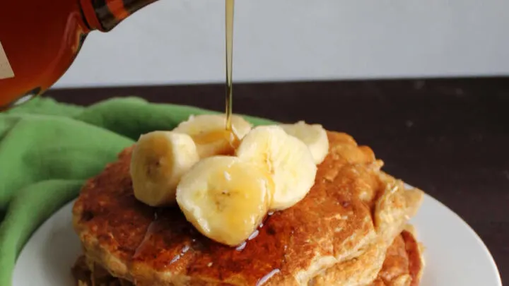 pouring syrup over banana oatmeal pancakes