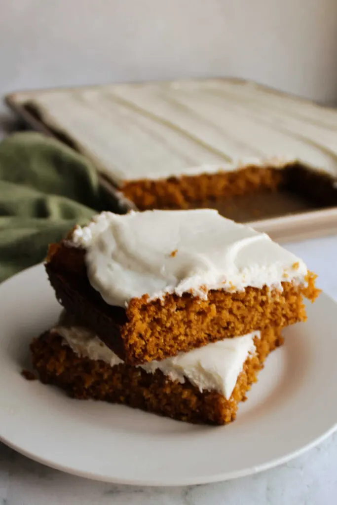 Pumpkin squares on plate in front of pan. 
