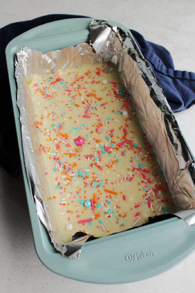 Pan of two tone fudge topped with colorful sprinkles.
