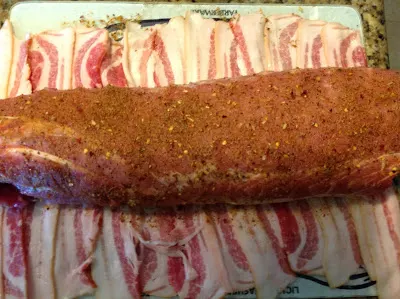 seasoned pork loin ready to be wrapped in bacon and put on the grill