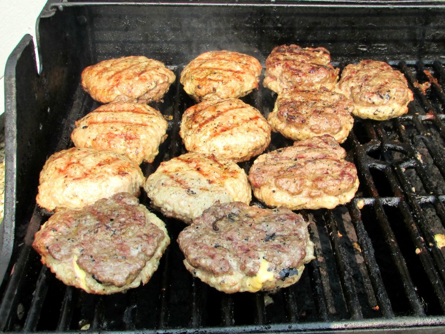Stuffed burgers that are beef on one side and pork on the other on the grill cooking.