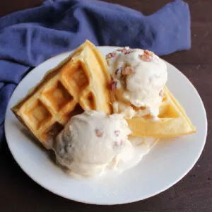 Plate of waffles with a couple of scoops of maple bacon ice cream.