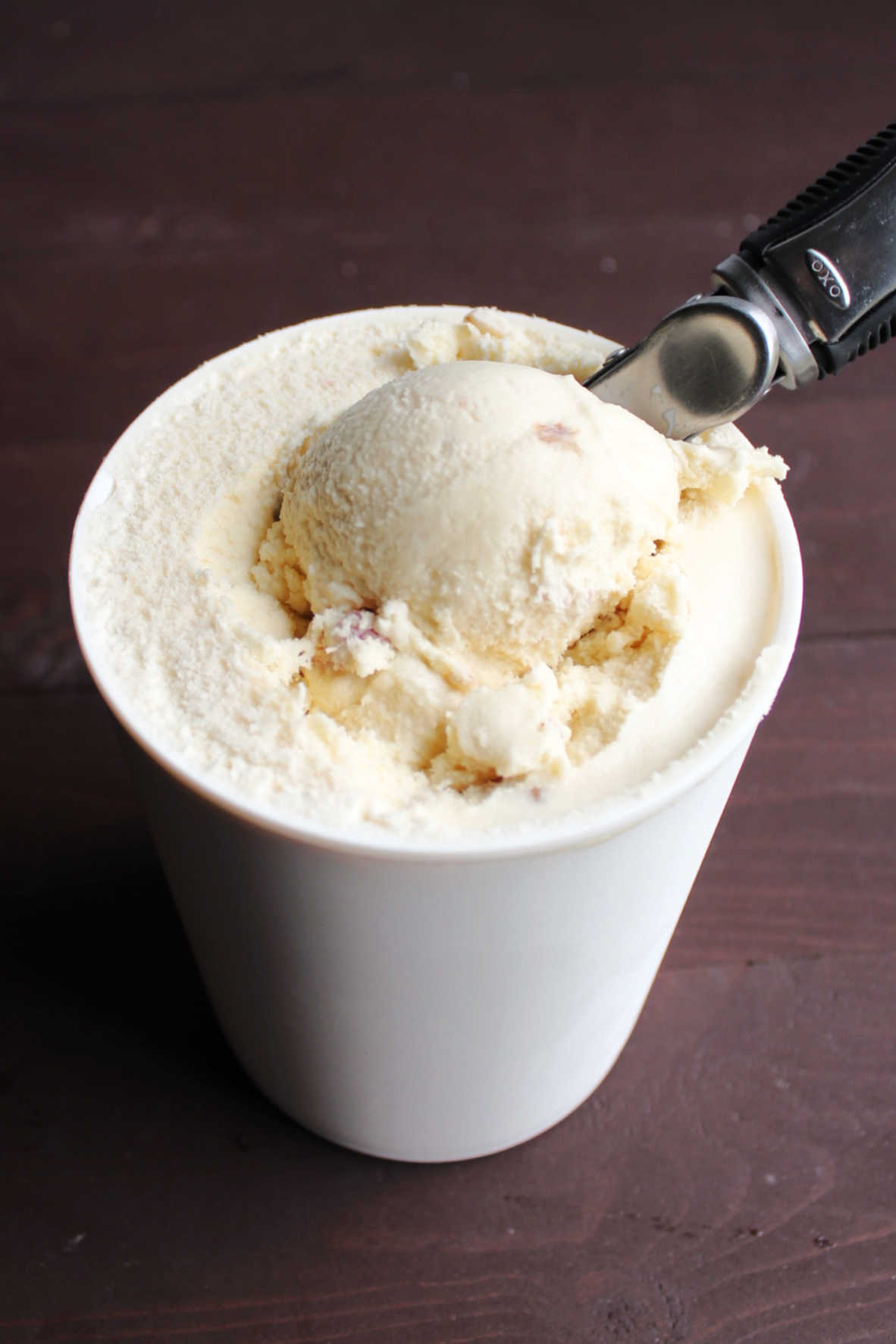 scooping out first helping of maple bacon ice cream from storage container.