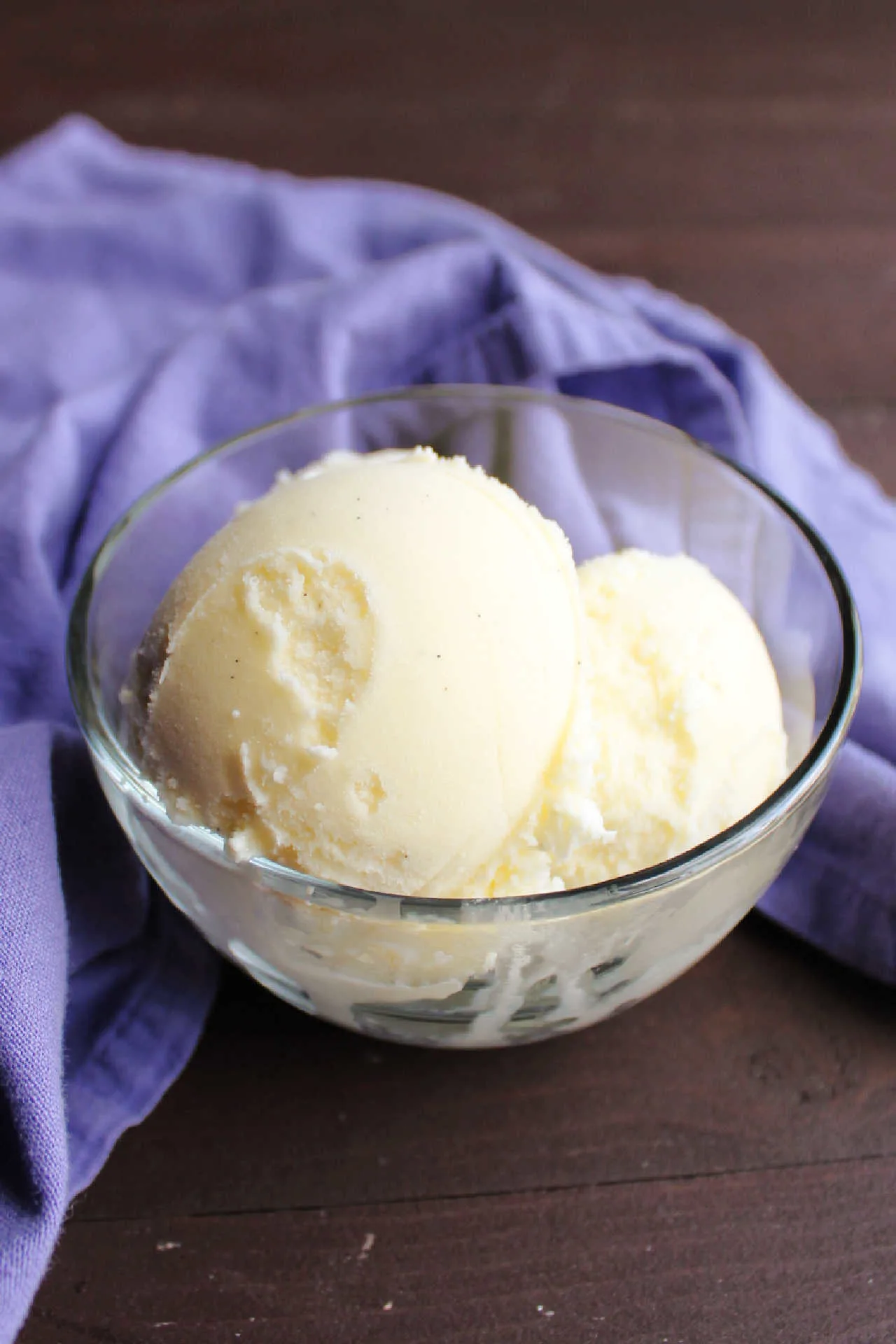 scoops of vanilla bean ice cream in glass bowl.