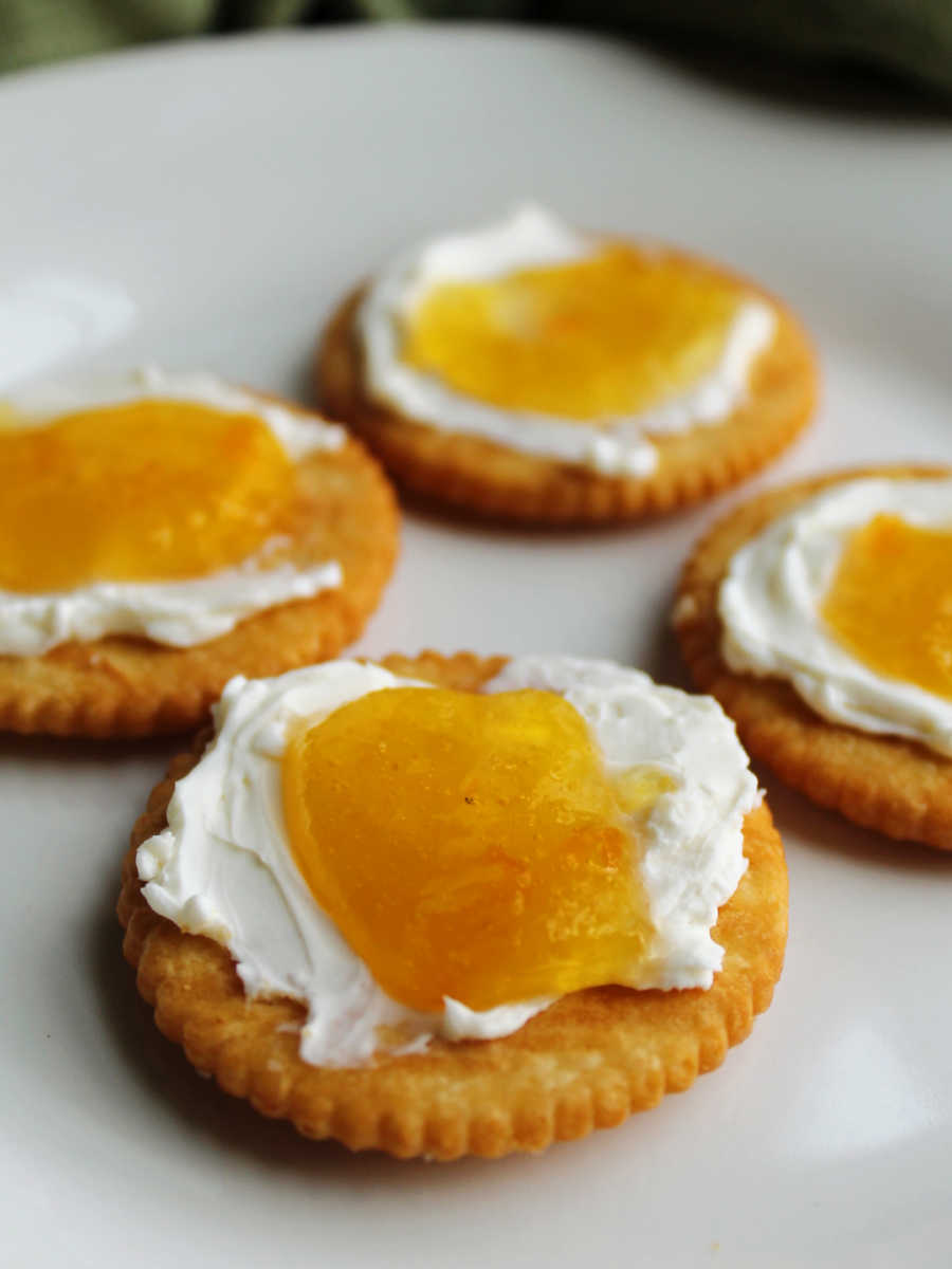 Crackers with a layer of cream cheese topped with peach habanero jelly.