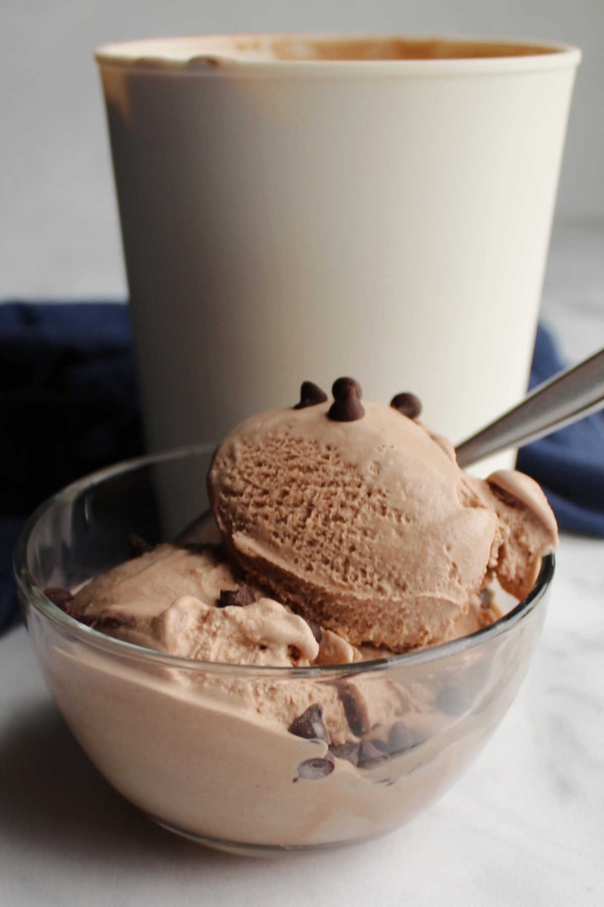 Small bowl of brownie batter ice cream with chocolate chips on top.