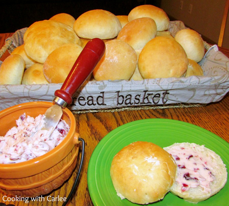 Basket of soft golden bars, with one cut open and spread with cranberry butter.