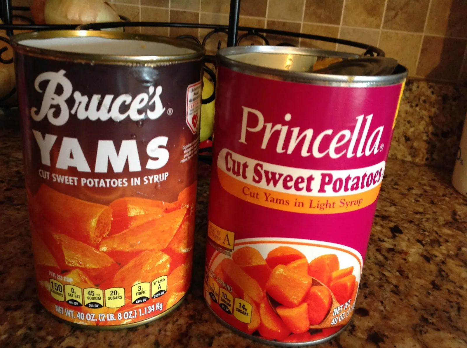 Two cans, one that says Bruce's yams with cut sweet potatoes in syrup in smaller print and the other says Princella cut sweet potatoes with cut yams in light syrup in smaller print.