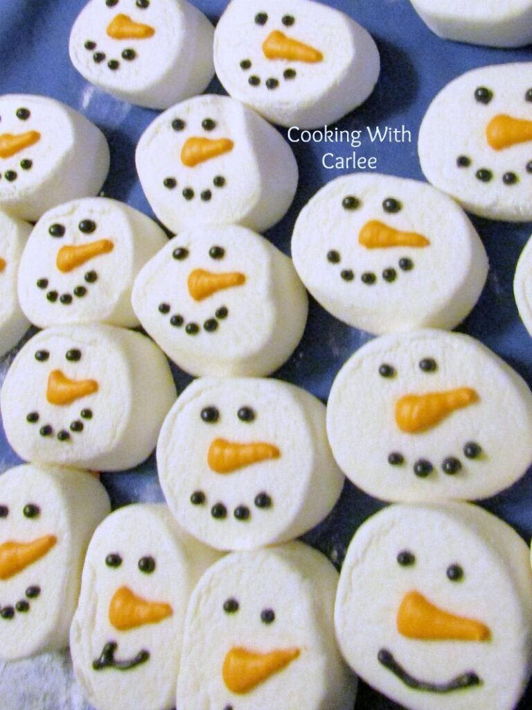 Marshmallows with royal icing eyes, mouths and carrots in royal icing.