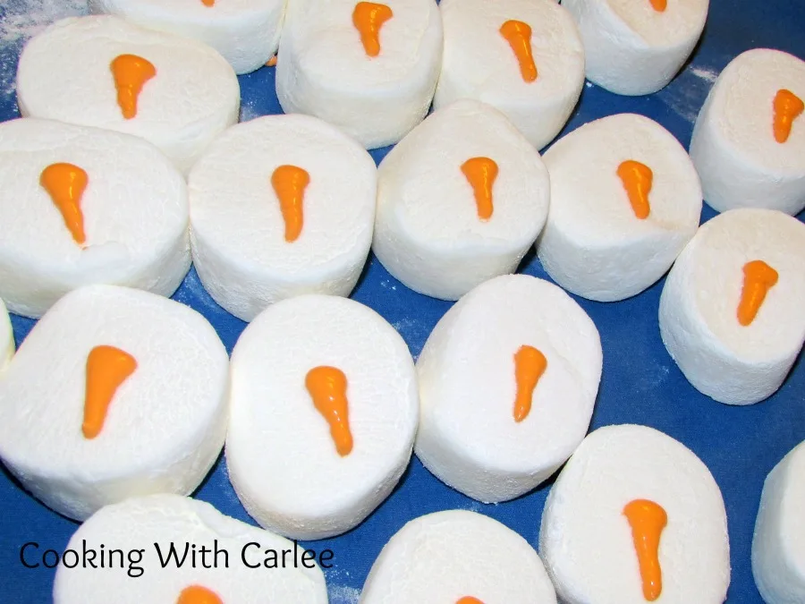 marshmallows with orange carrot shaped noses of royal icing piped on top.