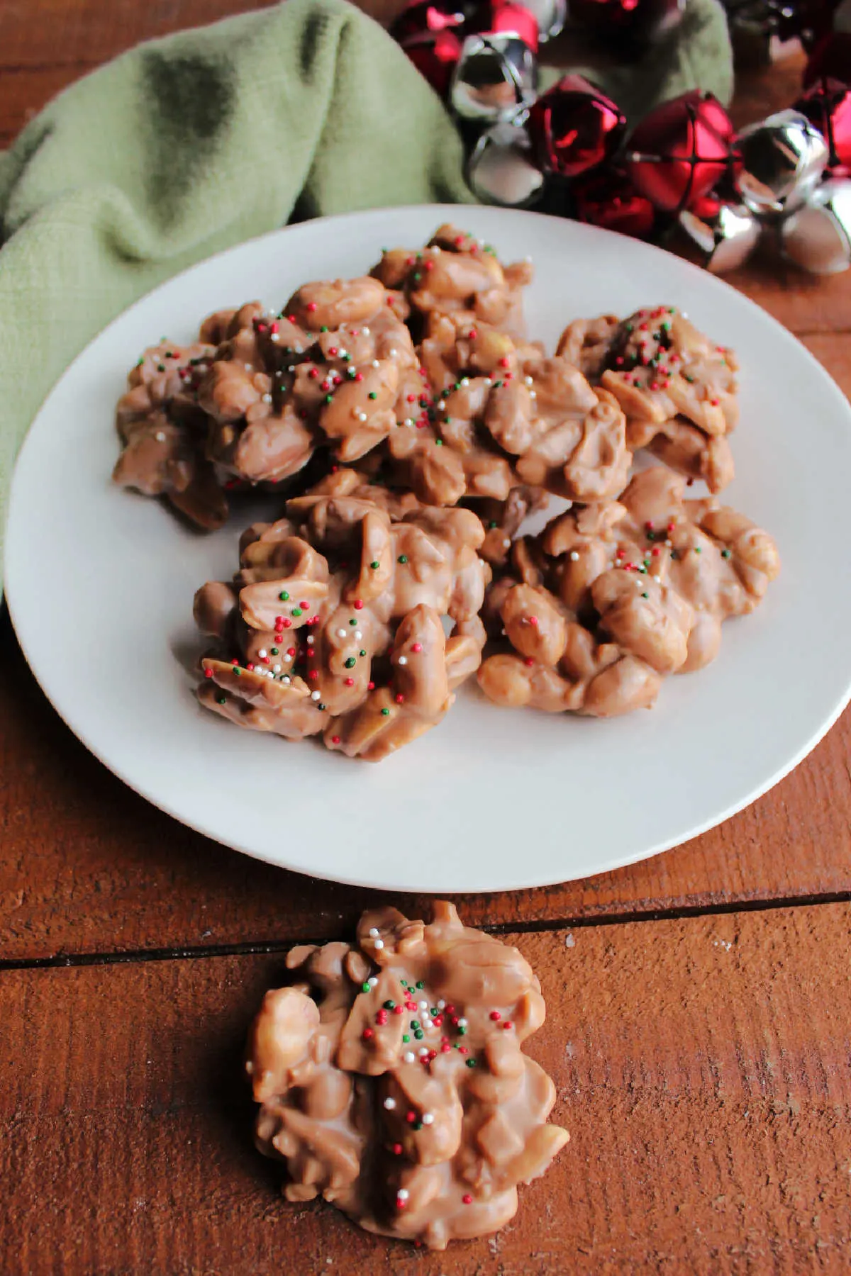 Easy slow cooker peanut clusters topped with Christmas sprinkles ready to be served.