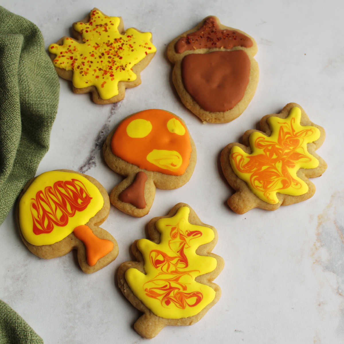 Cinnamon brown sugar cookies cut into leaf, mushroom and acorn shapes and decorated with royal icing.