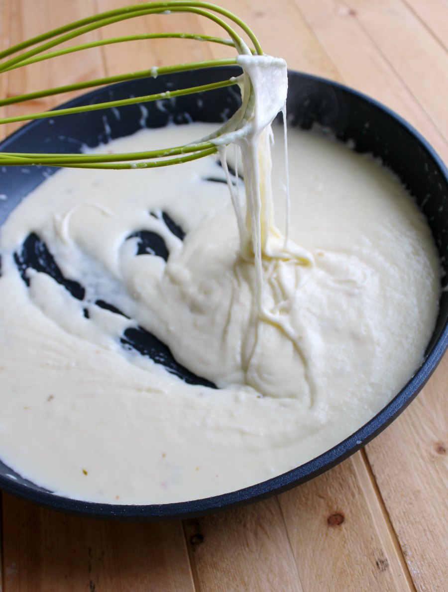 whisk with strings of cheese from white cheese sauce.