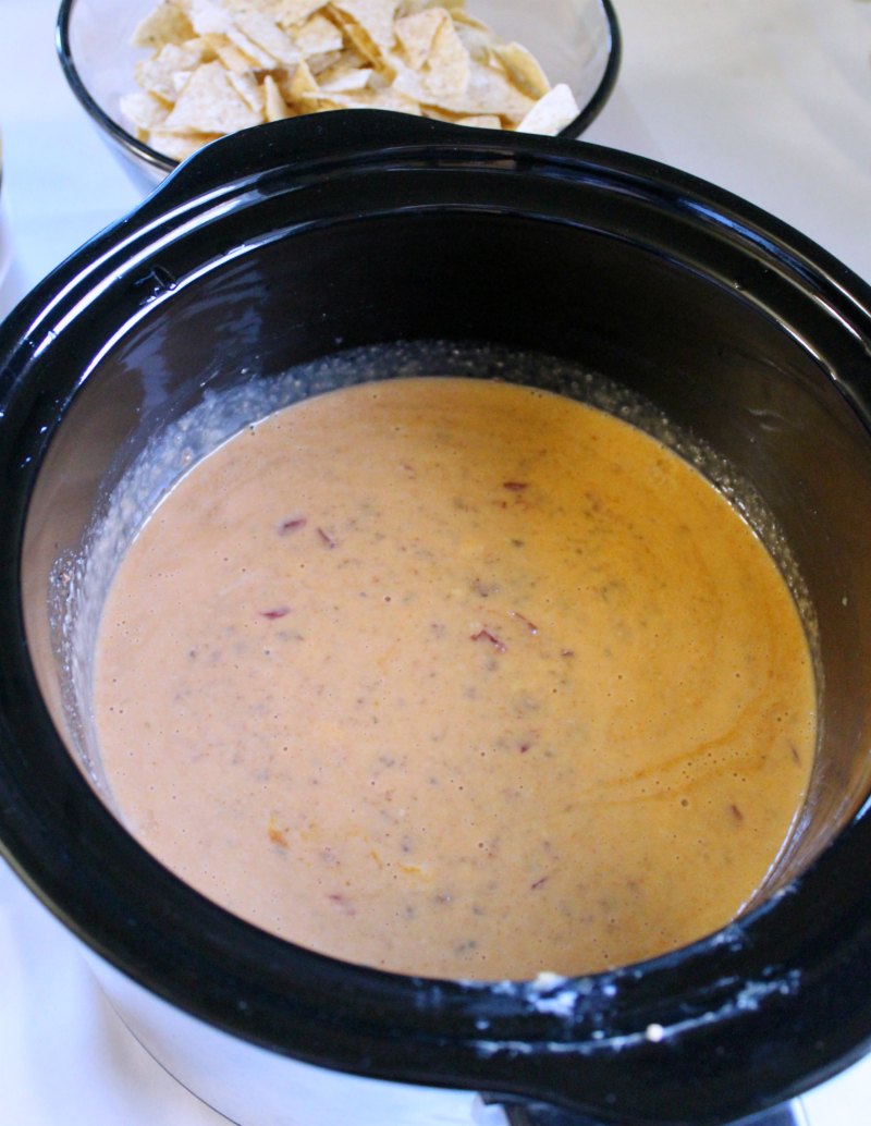 slow cooker filled with tailgate queso ready to enjoy.