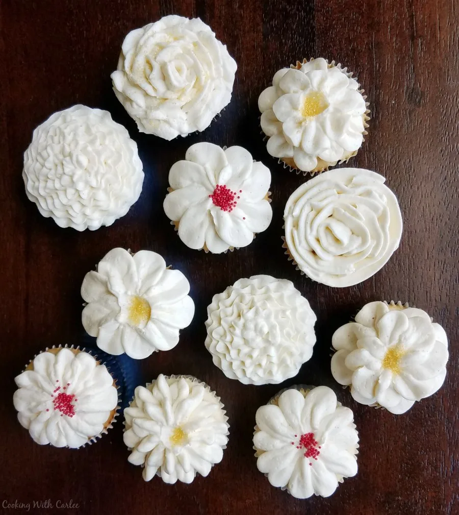 cupcakes decorated with bright white Italian meringue buttercream in various flower shapes