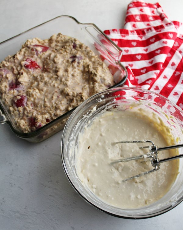 pan of strawberry baked oatmeal batter and mixing bowl filled with cream cheese filling ready to be mixed and baked.