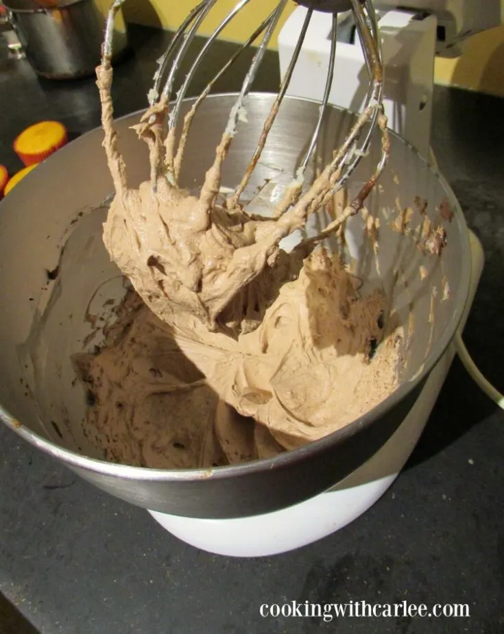 Stand mixer with fluffy mocha ermine frosting, ready to use.