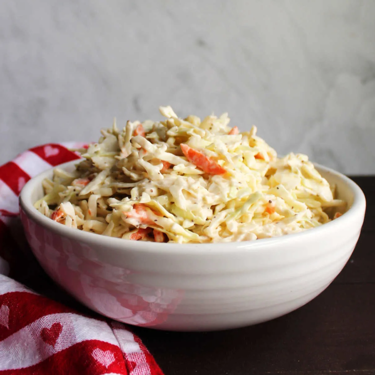 White serving bowl filled with creamy coleslaw.