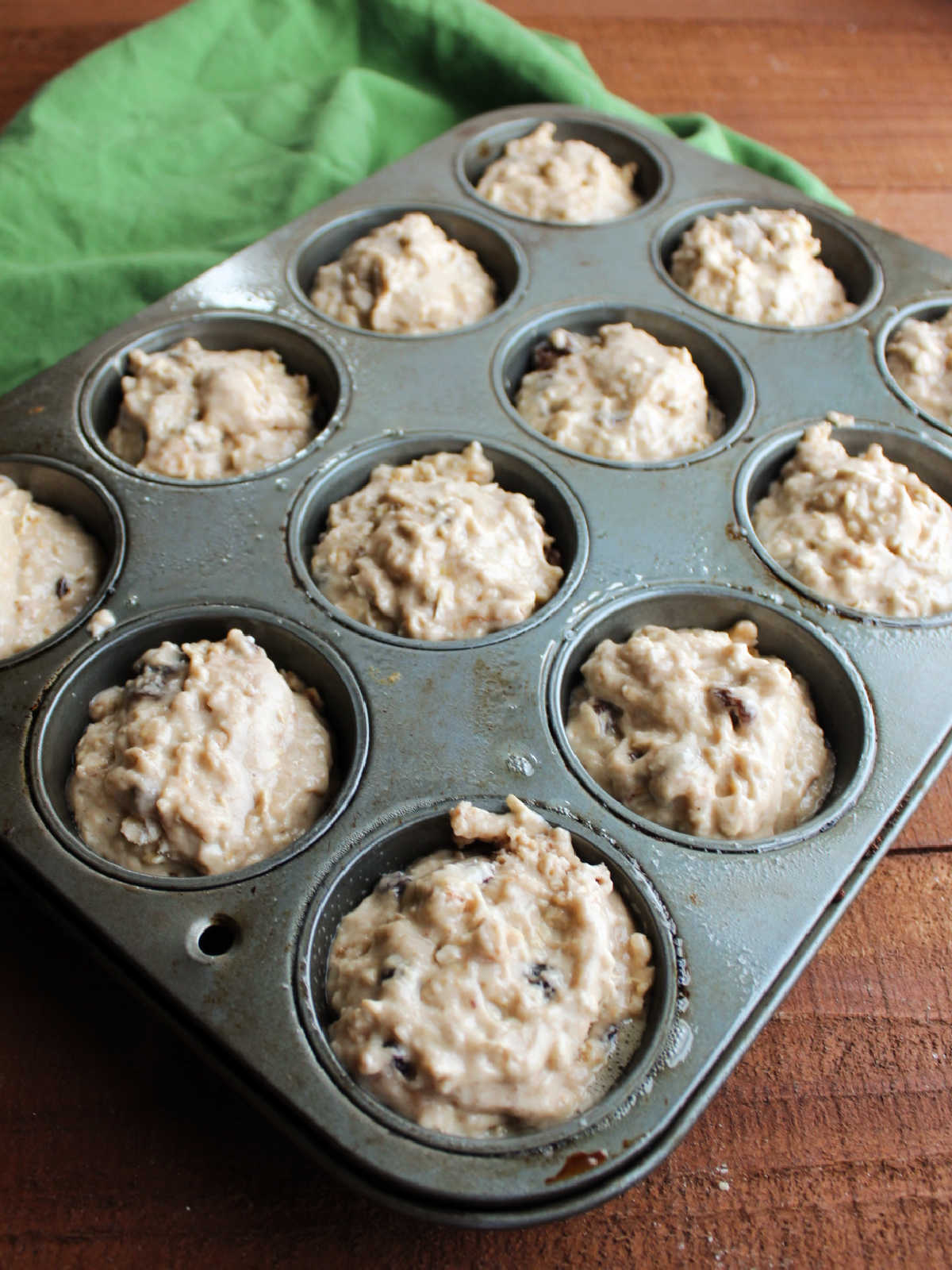 Oatmeal sourdough muffin batter in pan ready to go in the oven.