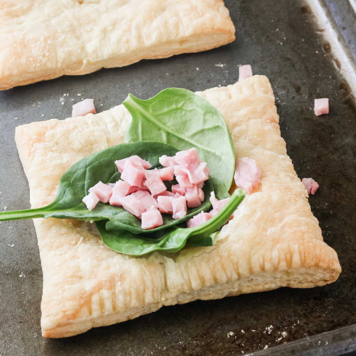 Spinach and ham on top of square of puff pastry.