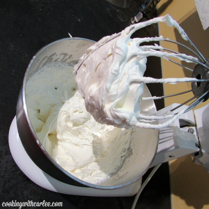 mixer bowl of cream cheese whipped cream on beater.