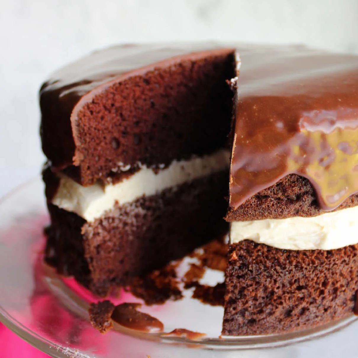 Chocolate ding dong cake with slice removed showing creamy white filling in the center.