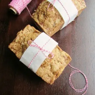 Two small loaves of zucchini bread tied up with parchment paper and baker's twine.