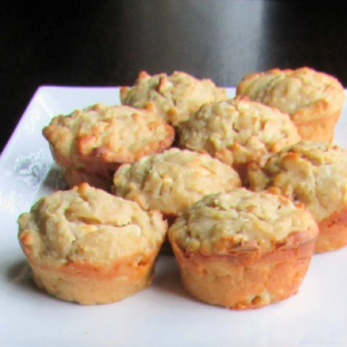plate of orange sourdough muffins with white chocolate chips.