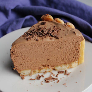slice of chocolate and coffee flavored no bake cheesecake with chocolate shavings on top