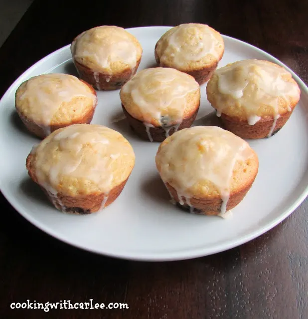 plate of muffins with white glaze on top.
