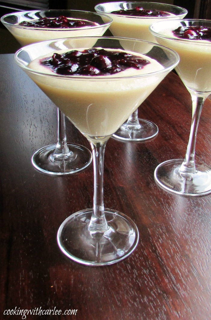 martini glasses filled with cornmeal budino (pudding) and topped with a blueberry marmellata sauce.
