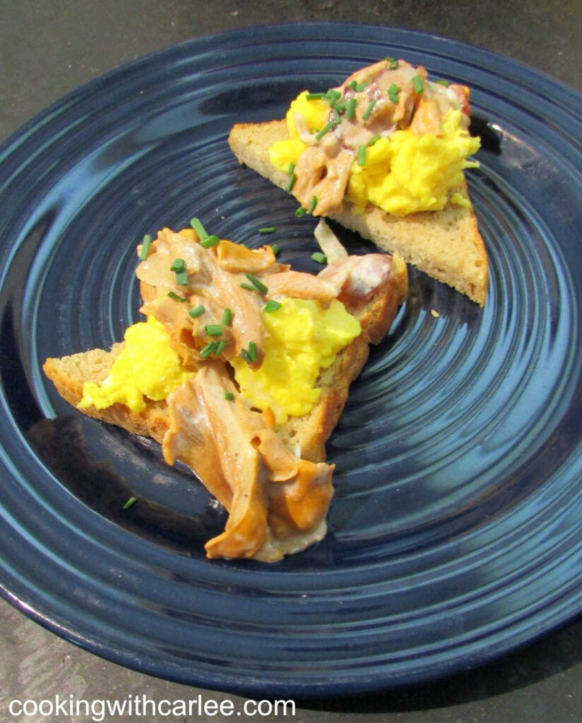 Pieces of toast topped with scrambled eggs and creamy russian style chanterelle mushrooms.