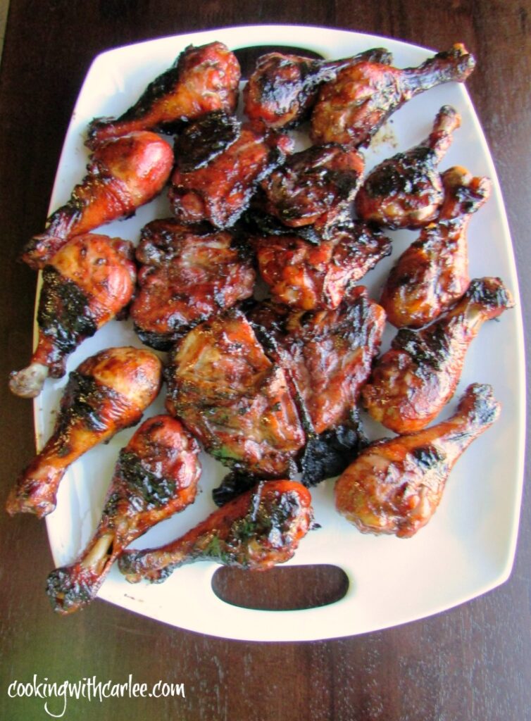 platter of shiny red grilled chicken drumsticks and thighs.