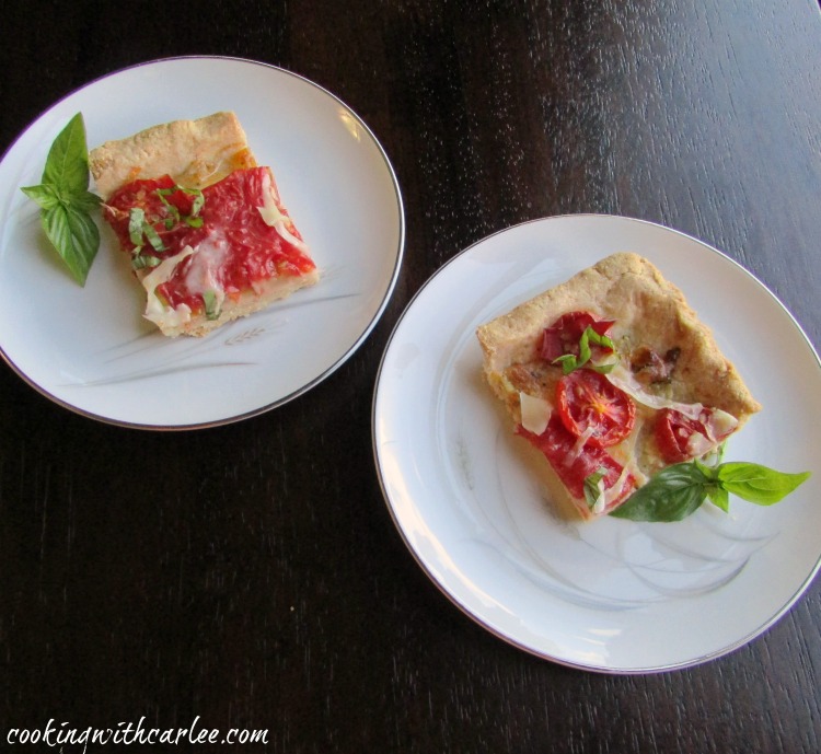 two small square pieces of tomato slab pie with cornmeal crust.