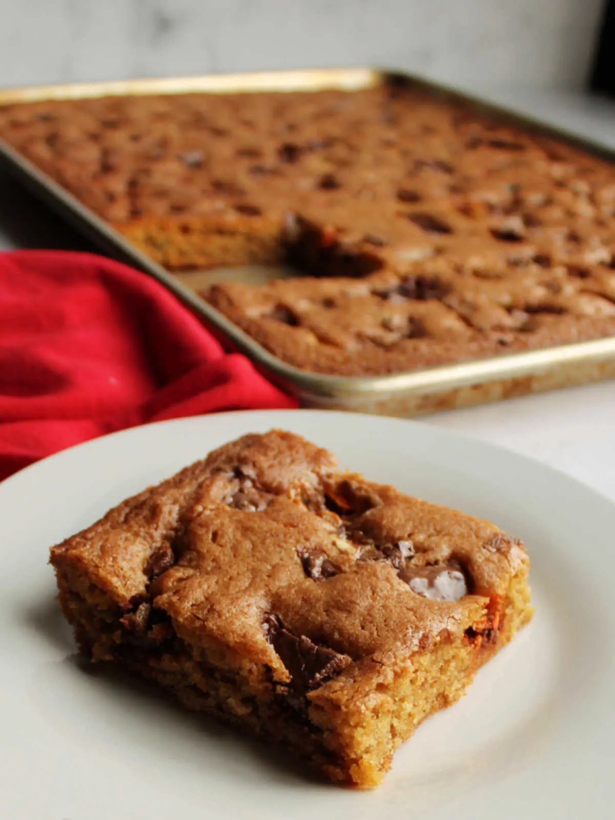 Close up of soft brown sugar blondie showing chewy texture with pieces of candy on top.
