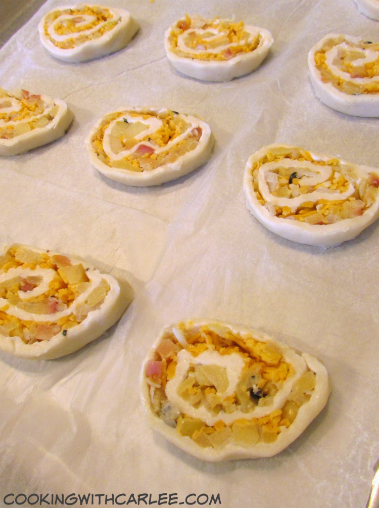 puff pastry dough wrapped around apple  filling cut into slices and ready to bake. 