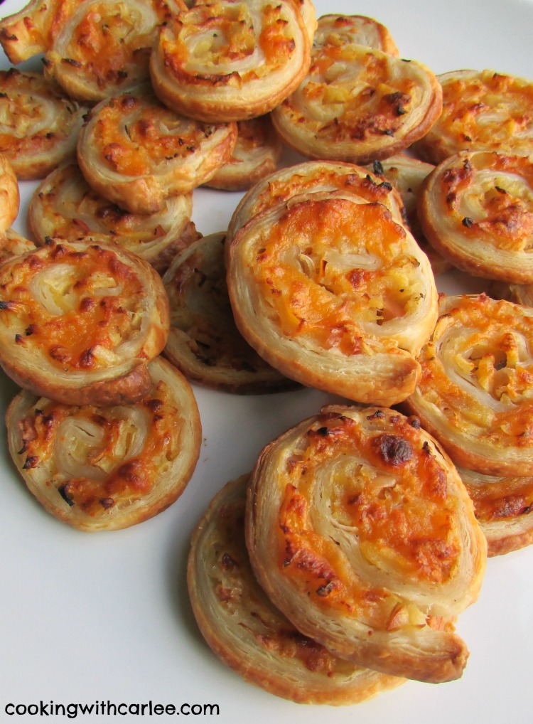 Plate filled with fresh baked apple and cheddar puff pastry pinwheels.