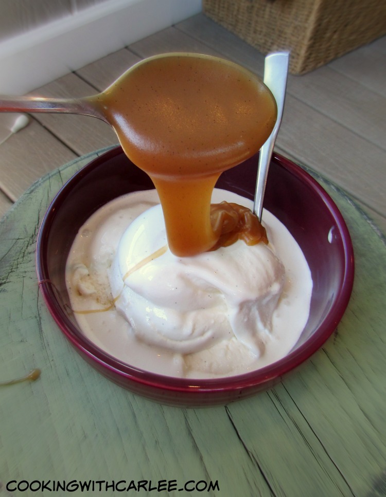 Drizzling apple cider caramel sauce over a bowl of vanilla ice cream. 