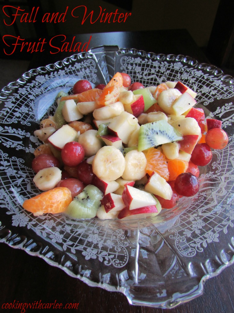 Bowl of lightly dressed fruit salad with apples, oranges, kiwi and more.